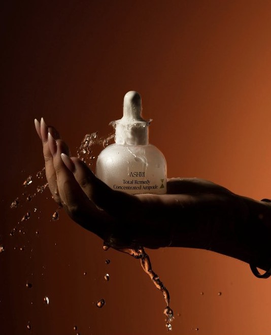 ASHRI Total Remedy Concentrated Ampoule held in a splash of water