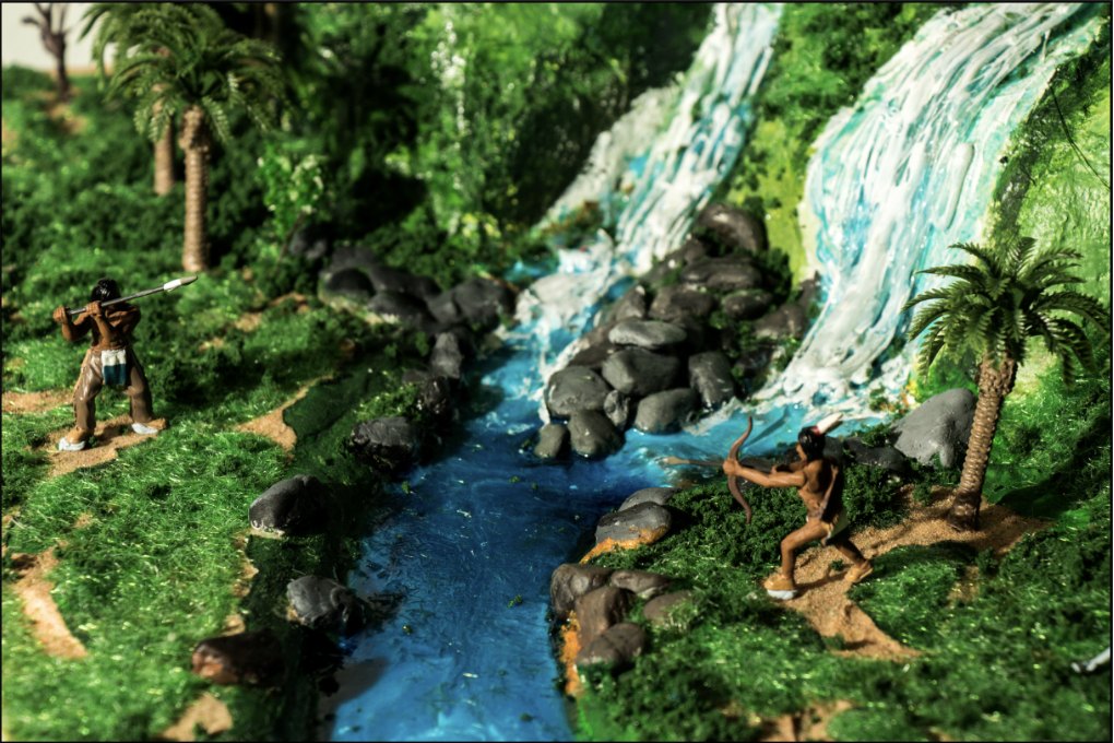 Miniature hunters beside the model waterfall
