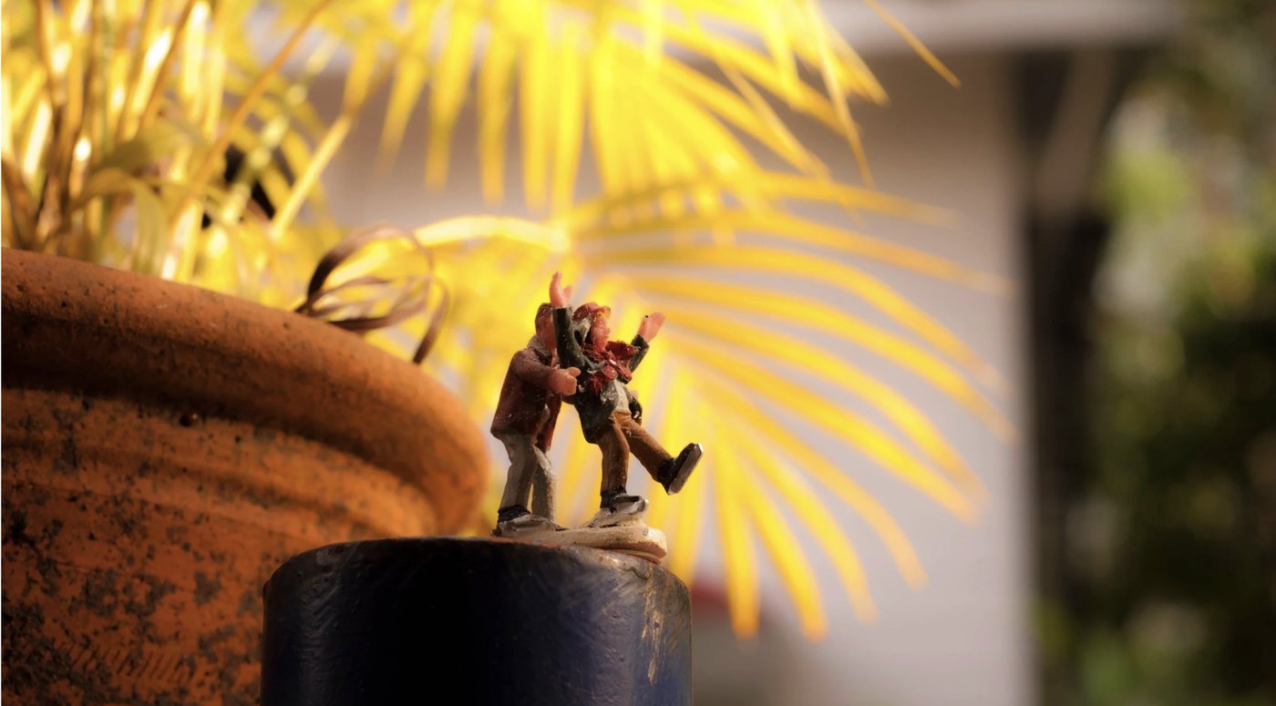 Miniature figures skating beside a terracotta pot
