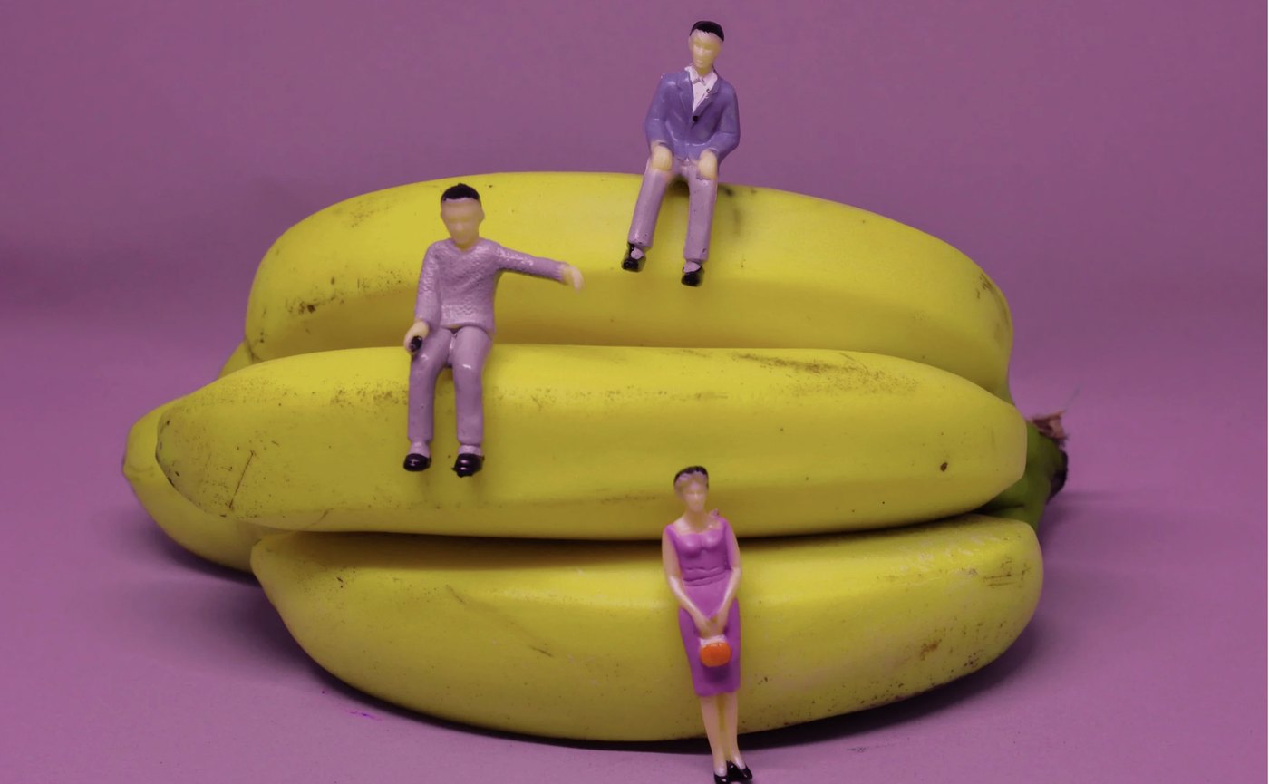 Miniature figures sitting on bananas
