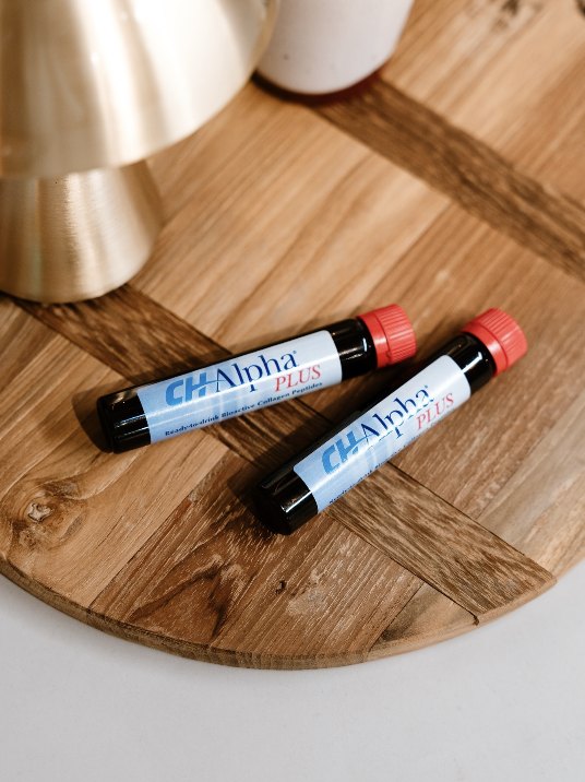 Two CH-Alpha Plus vials on a wooden board