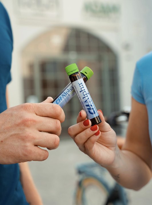 Two friends clinking CH-Alpha vials